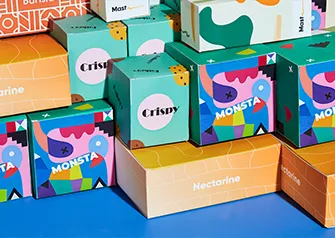 Custom printed folding boxes in colorful branded designs stacked together by Packwire