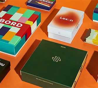 Variety of Packwire custom rigid boxes with branded printing on orange surface