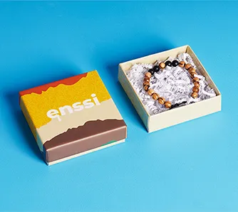 Custom rigid jewelry box with branded lid and bracelet on crinkle paper