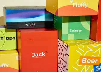 Collection of colorful custom branded corrugated shipping boxes stacked from multiple companies